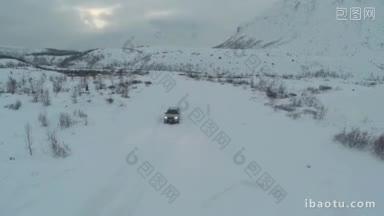 航拍的银色汽车在雪地里沿着公路行驶